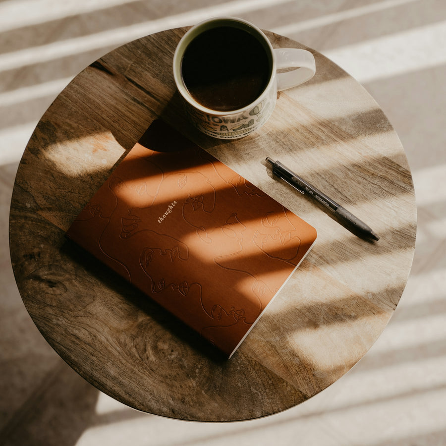 Libreta abierta y taza de café para planificar hábitos